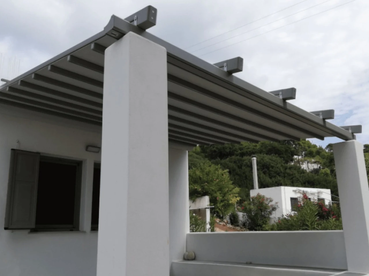 Λευκή βιοκλιματική πέργκολα σε κήπο
